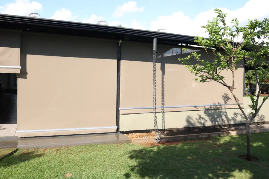 Cortinas verticais bege fechando a lateral de uma varanda